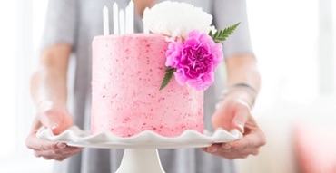 Person holding a pink cake